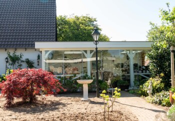 Glazen schuifwand in landelijke romantische overkapping achtertuin