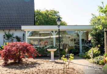 Glazen schuifwand in landelijke romantische overkapping achtertuin